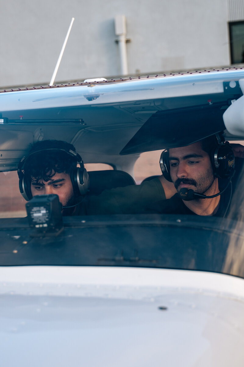 Flight instructor and student reviewing instruments together in a training aircraft cockpit